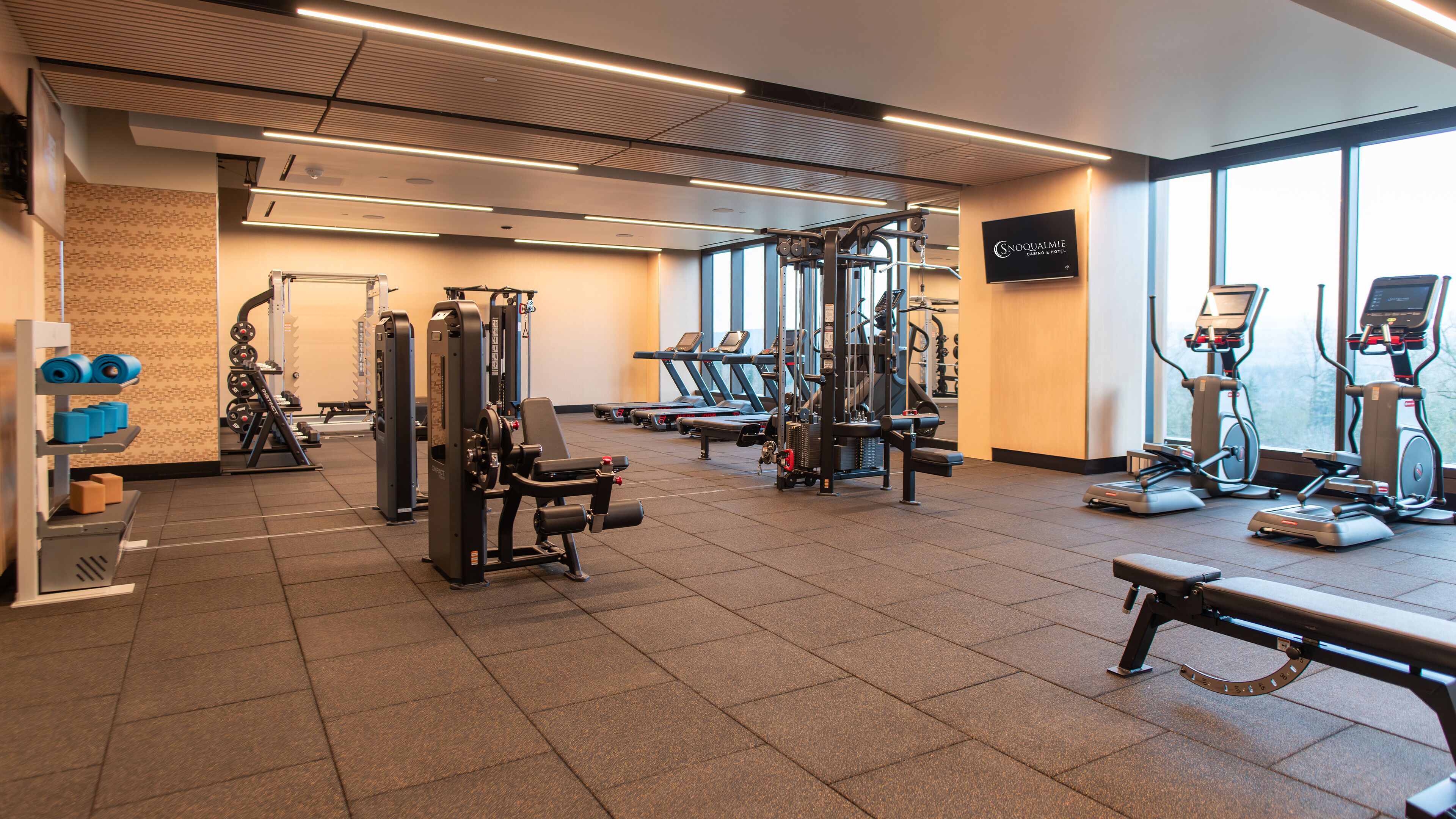 A gym with cardio machines, weightlifting equipment, and treadmills.