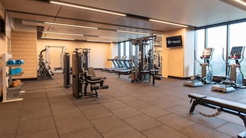 A gym with cardio machines, weightlifting equipment, and treadmills.