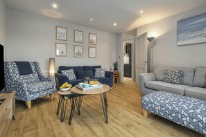 A living room with two sofas, a coffee table, and a TV.