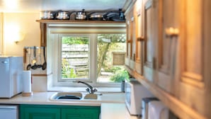 Cucina con mobili verdi, una finestra e un lavandino.