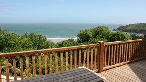 A wooden deck with a view of the ocean and a beach. - Stella Maris, Freshwater East (Freshwater East)