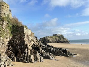 A coastal landscape with a stone fortification and a beach. - South Seas, Tenby - Five Bedroom Cottage, Sleeps 10 (Tenby)