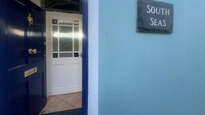 Ovi, jossa on vaaleansinisellä seinällä kyltti, jossa lukee ”SOUTH SEAS”.
