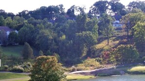 Un campo de golf con búnkeres de arena, un estanque y árboles.