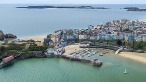 A coastal town with a harbor, sandy beach, and a mix of colorful buildings. - Puffins Nest, Tenby - Two Bedroom Cottage, Sleeps 4 (Tenby)
