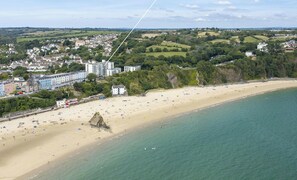 Aerial view of Puffin's Nest, overlooking one of Tenby's sandy beaches and calm sea with green hills behind - Puffins Nest, Tenby - Two Bedroom Cottage, Sleeps 4 (Tenby)