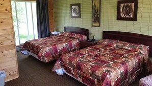 A room with two beds, a window with curtains, and a green tiled wall. - Cedar Creek Standard 1 (East Braintree)