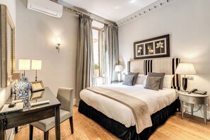 Habitación de hotel con una cama grande, mesitas de noche, un escritorio con silla y un espejo amplio.