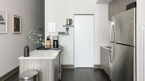Una cucina moderna con piano cottura integrato, frigorifero e macchina da caffè.
