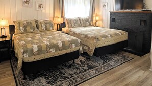 A bedroom with two beds, a fireplace, and a TV. - Hinckleys Dreamwood Cottages (Bar Harbor)