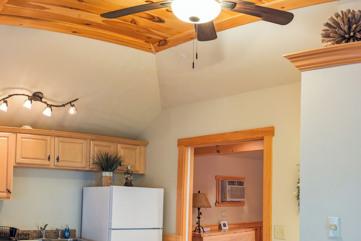 A kitchen with wooden cabinets, a white refrigerator, and a ceiling fan.