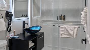 Une salle de bain moderne équipée de toilettes, d’un lavabo et d’une douche.