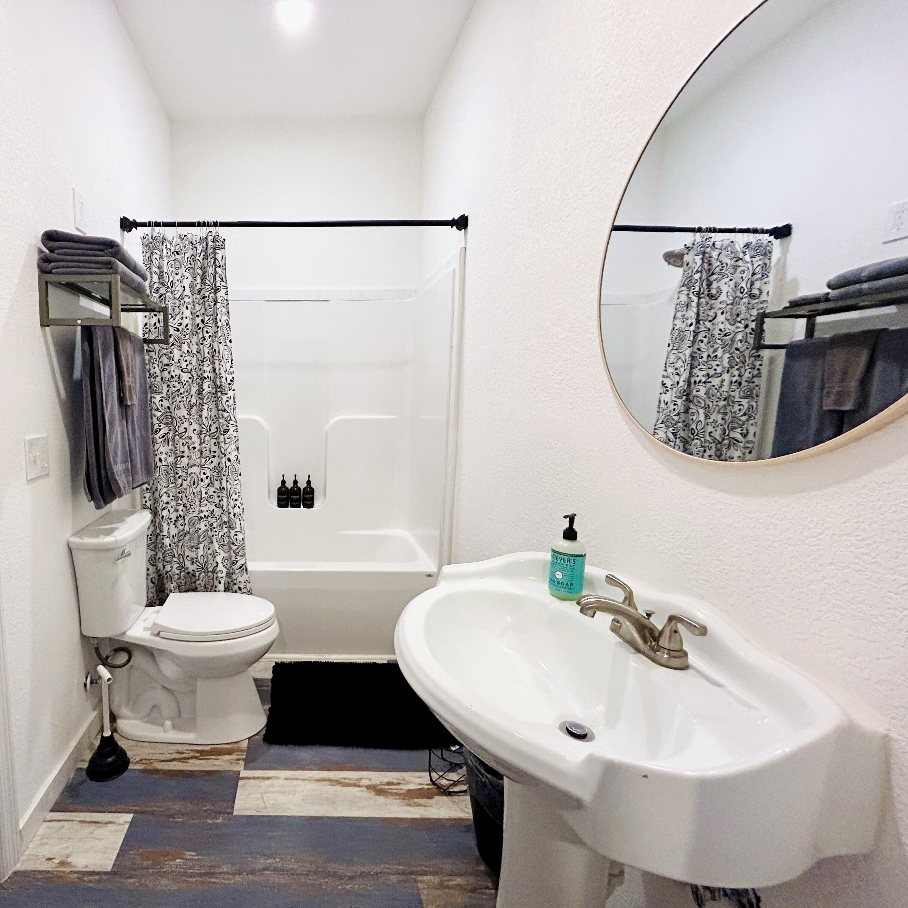Ein Badezimmer mit Toilette, Badewanne, Waschbecken und Spiegel.