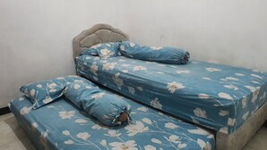 A bed with a floral bedspread and matching pillows. - Hotel O Abang Homestay Syariah (Surabaya)