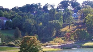 A golf course with a pond, sand bunkers, and trees.