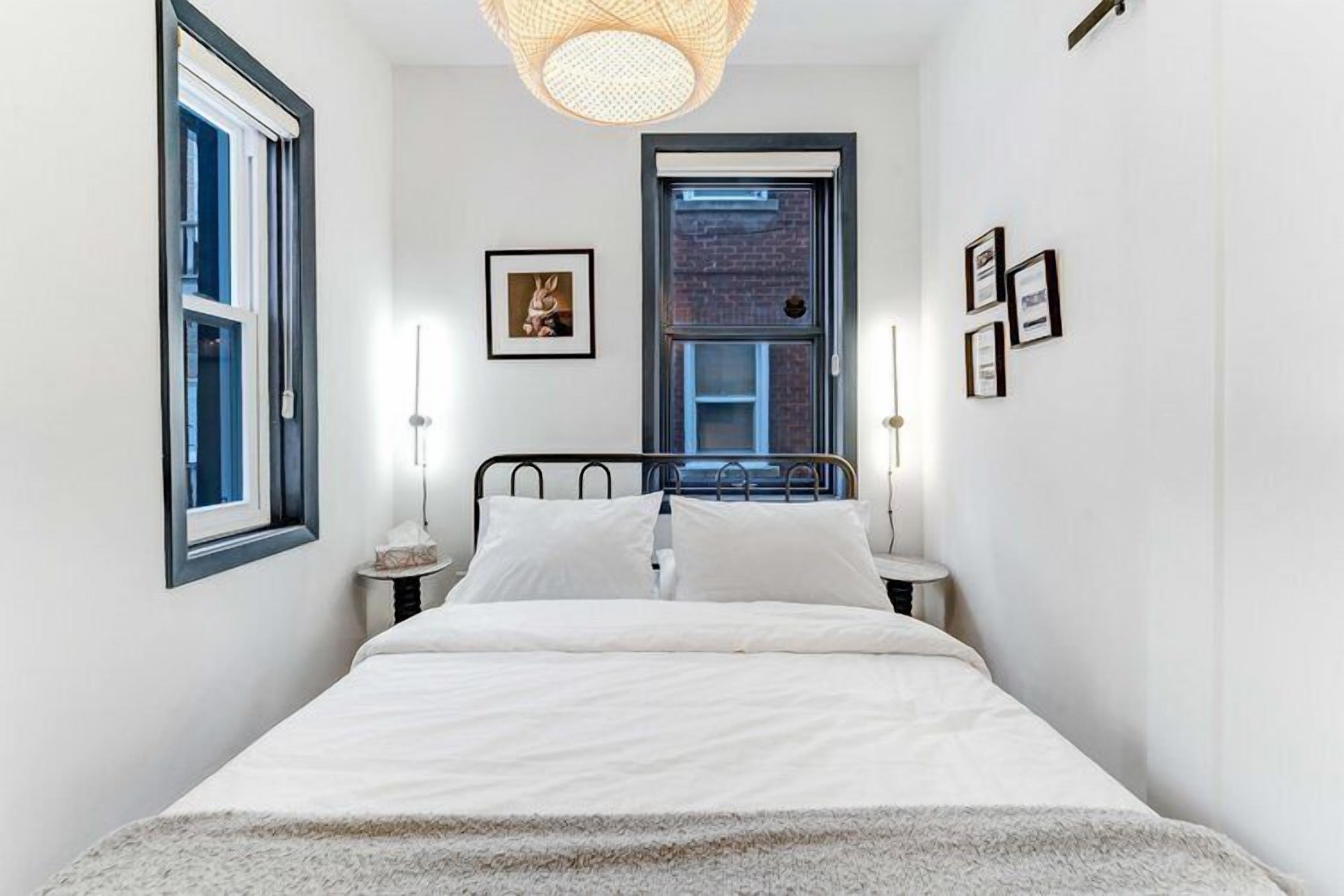 A bedroom with a bed, bedside tables, a window, and a door.