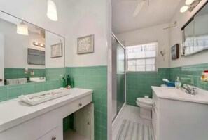 Une salle de bain avec douche, toilettes et lavabo.