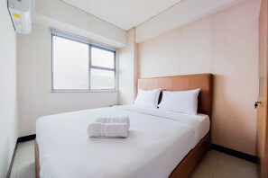 Hotelkamer met een groot bed, een raam met luxaflexen, een wandairconditioner en een deur.
