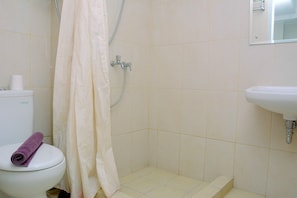 A bathroom with a toilet, shower, and sink. - Fully Furnished With Comfortable Design Studio Springlake Summarecon Apartment (Bekasi)