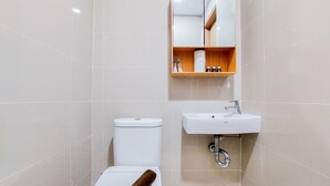 Une salle de bain moderne équipée de toilettes, d’un lavabo et d’un miroir.