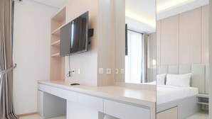 A modern bedroom with a large bed, a desk, and a TV mounted on the wall. - Nice And Comfort 1Br At 25Th Floor Samara Suites Apartment (Jakarta)