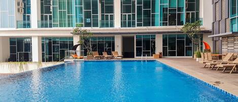 Un edificio moderno con una amplia piscina cubierta, varias zonas de descanso y grandes ventanales.