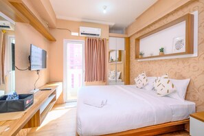Une chambre d’hôtel équipée d’un lit, d’une télévision, d’un bureau et d’une armoire.