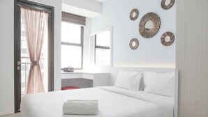 Una habitación de hotel moderna con una cama grande, un escritorio y una ventana con cortinas.