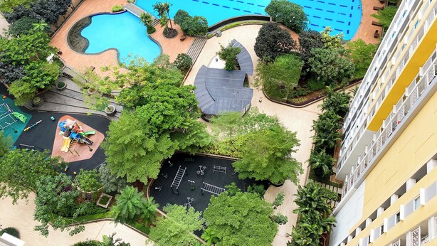 Ein Wohnkomplex mit Schwimmbad, Spielplatz und umliegender Grünfläche.