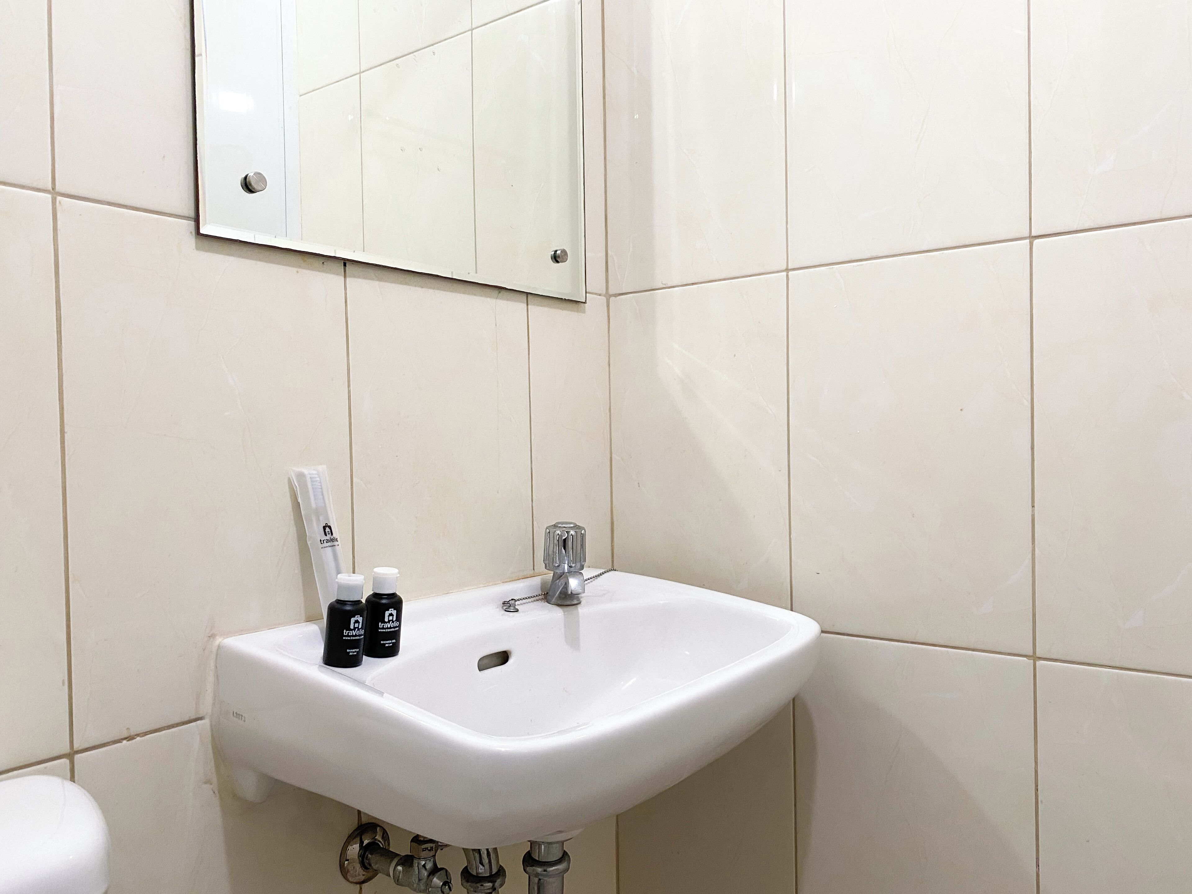 Ein Badezimmer mit Waschbecken, Spiegel und Pflegeprodukten.