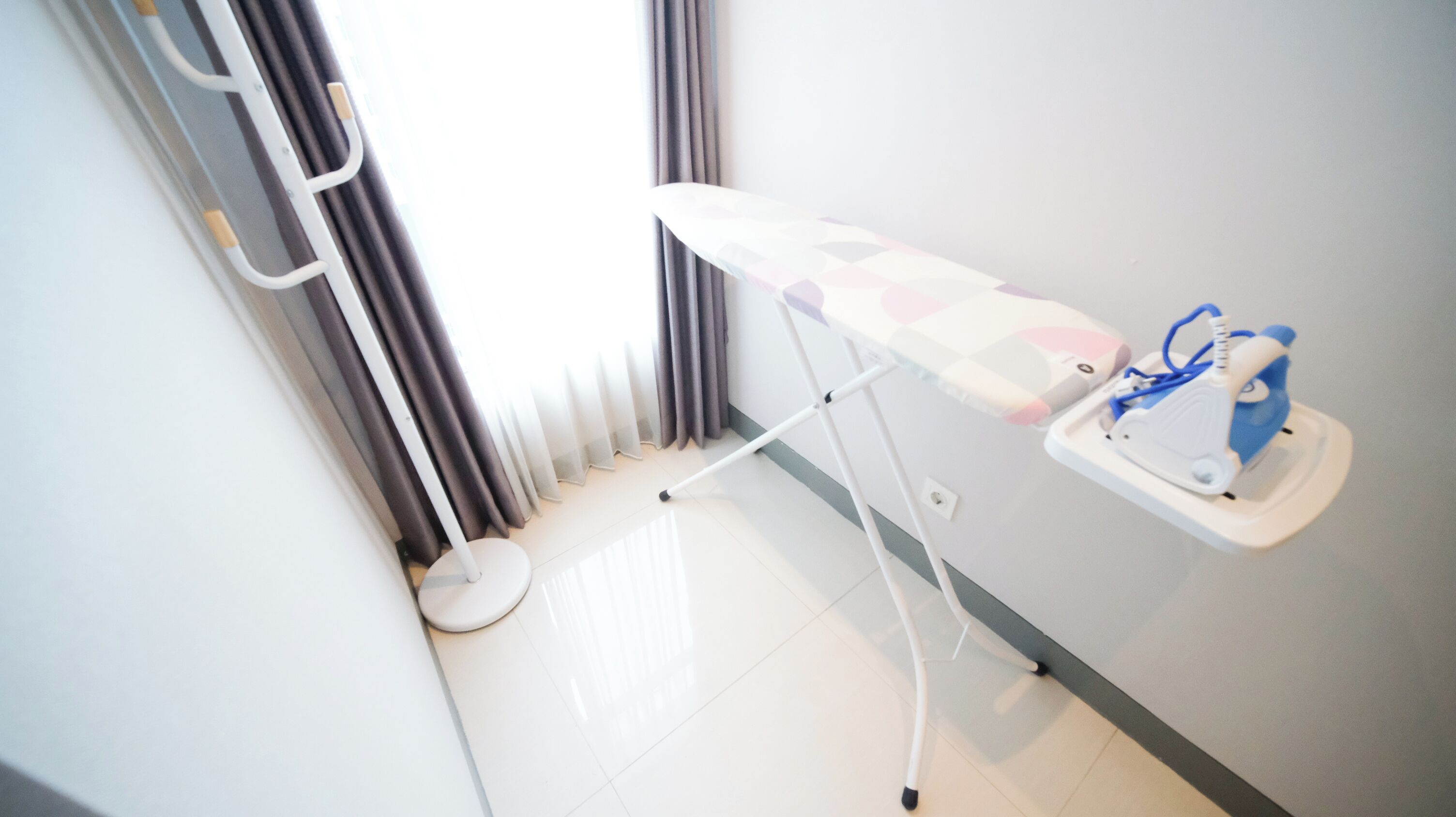 A clinical setting with a white examination table, a blue and white medical device, and a white stool.