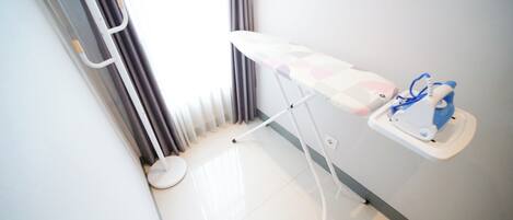 A clinical setting with a white examination table, a blue and white medical device, and a white stool.
