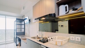 Eine moderne Küche mit Gasherd, Spüle und Holzschränken.