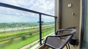 Parvekkeella on kaksi tuolia, ja sieltä on näkymä moottoritielle sekä viheralueille.