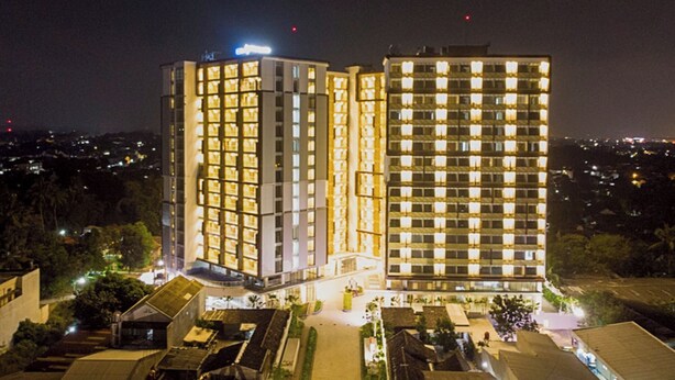 Un hotel de varios pisos con ventanas iluminadas y un patio central.