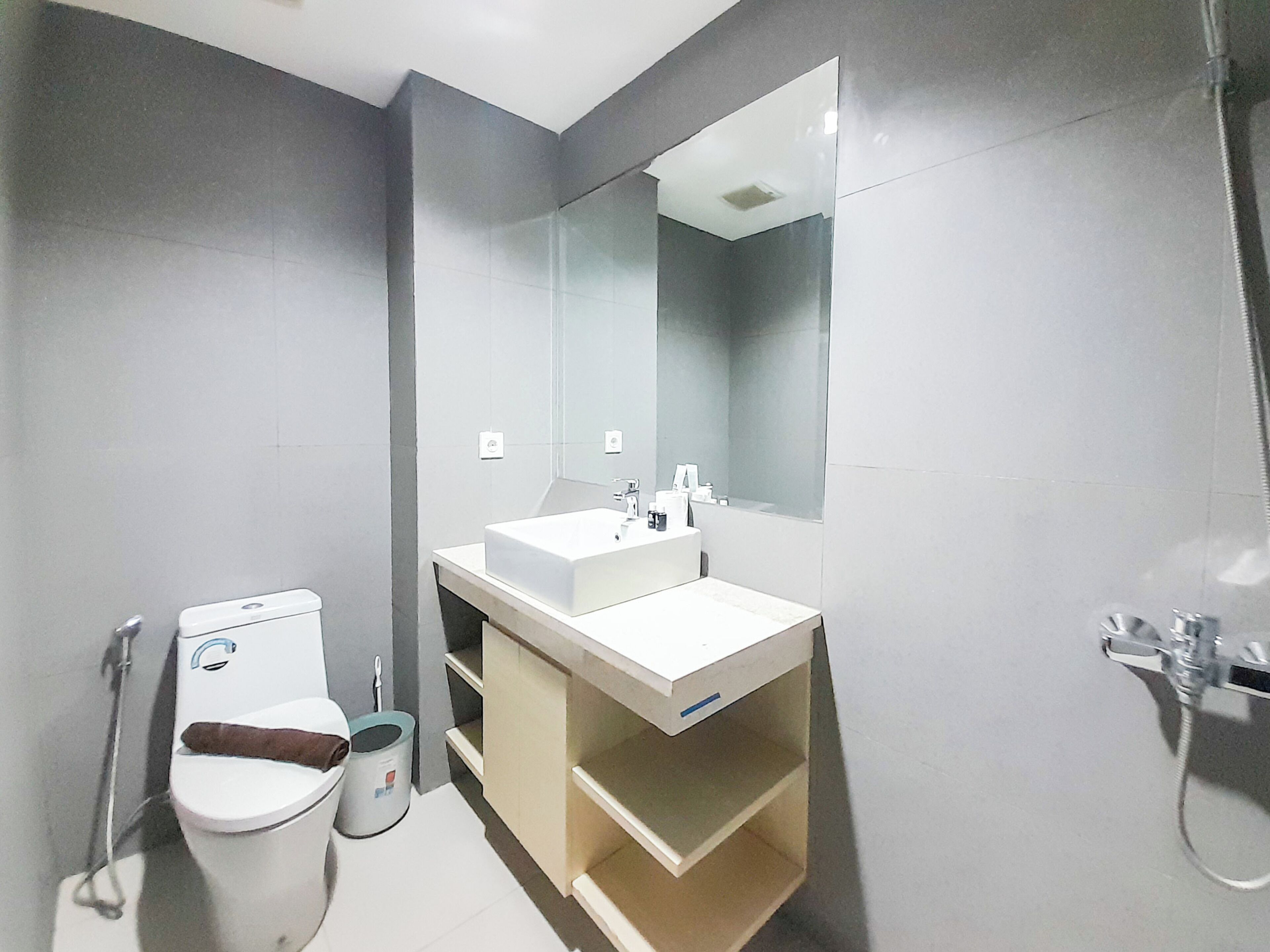 Ein modernes Badezimmer mit Waschbecken, Spiegel und Toilette in Weiß.