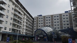 Een hotel met meerdere verdiepingen, modern van ontwerp, met balkons en een centraal glazen gebouw.