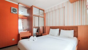 Een hotelkamer met een groot bed, een spiegel, een kaptafel en een gestreept wandontwerp.