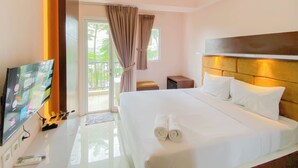 A hotel room with a large bed, a flat-screen TV, a bedside table, and a view of the outdoors through a sliding door. - Well Design And Homey Studio Signature Park Grande Apartment (Jakarta)