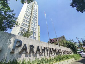 Señal de la Regencia de Parahyangan, con un edificio alto al fondo.