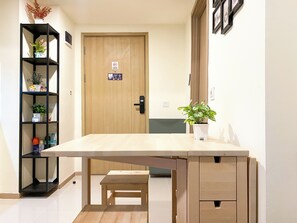 Simple, stylish space with a wooden door, small table, and shelving unit.