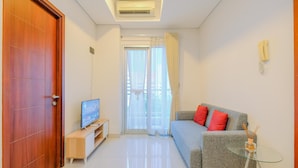 A living room with a TV, sofa, and glass table. - Good Choice And Elegant 2Br Apartment Capitol Park Residence (Jakarta)