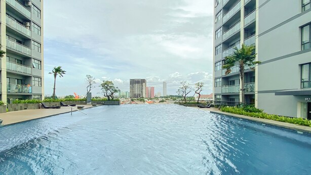 A swimming pool with a view of modern apartment buildings and a clear sky.