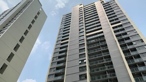 A high-rise building with multiple floors, large windows, and balconies.