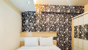 A hotel room with a bed, floral wallpaper, and a sliding door. - Best Deal And Comfy 1Br Apartment Gateway Ahmad Yani Cicadas (Bandung)