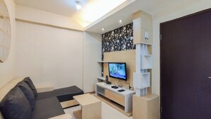 A modern living room with a sofa, coffee table, TV, and built-in shelves. - Best Deal And Comfy 1Br Apartment Gateway Ahmad Yani Cicadas (Bandung)