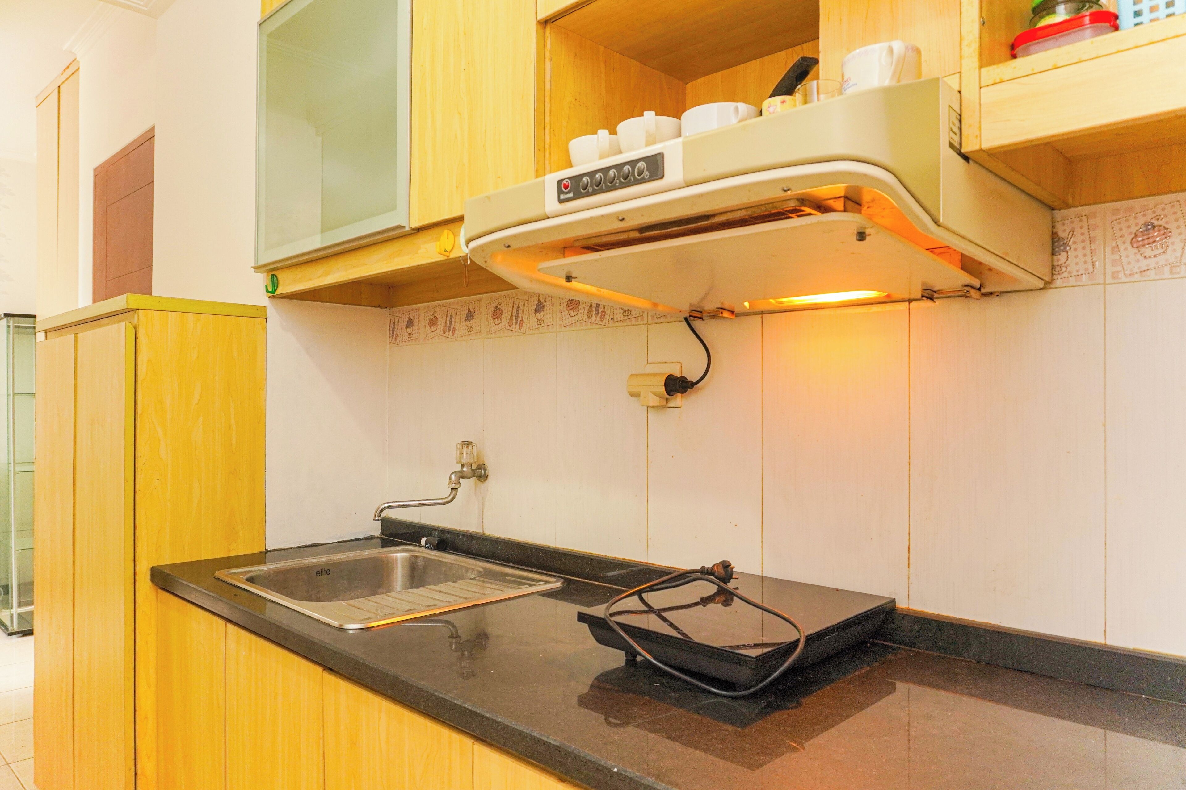 A kitchen with wooden cabinets, a stainless steel sink, and a built-in microwave.
