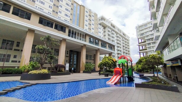 A residential building with a swimming pool and a children's play area.