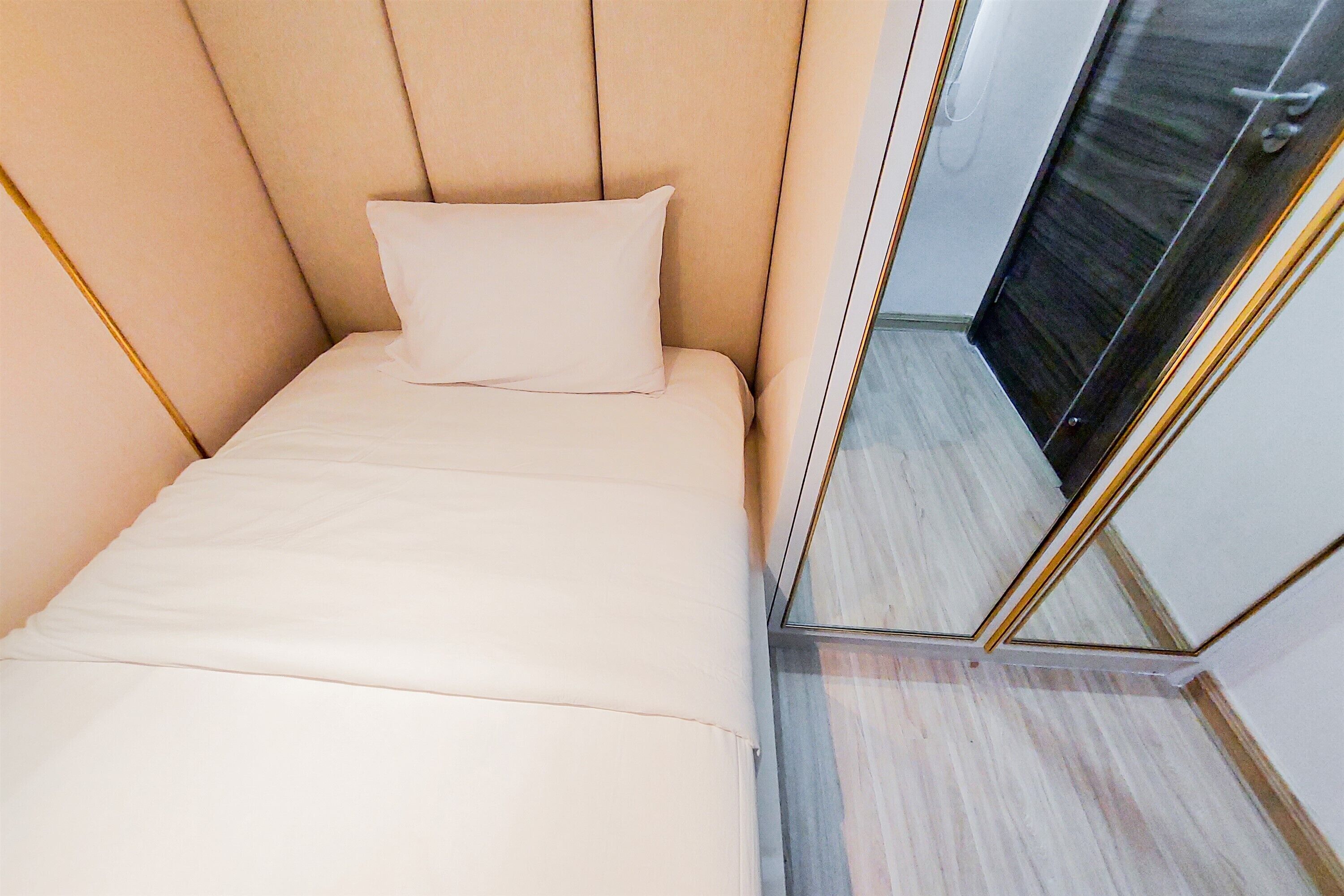 Ein modernes Schlafzimmer mit einem Bett, einem Spiegel und einer Tür.