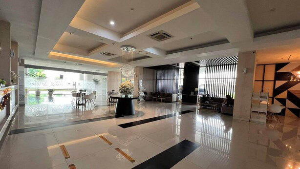 A spacious lobby with a reception desk, seating area, and a large chandelier. - Best Studio At Taman Melati Surabaya Apartment (Surabaya)